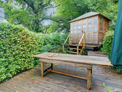 汤顿Hill view Holiday Home with Garden的甲板上小房子旁边的木凳