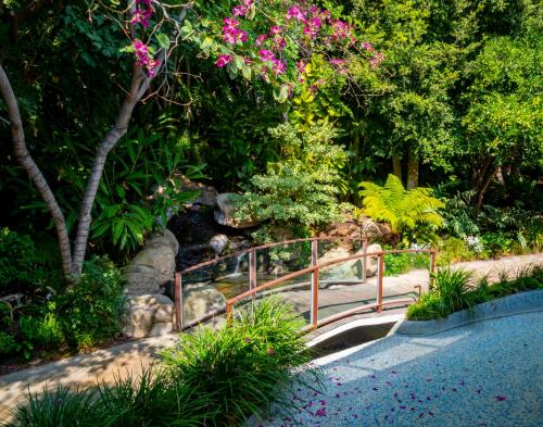 洛杉矶日落侯爵酒店的花园中一座种满鲜花和树木的桥梁