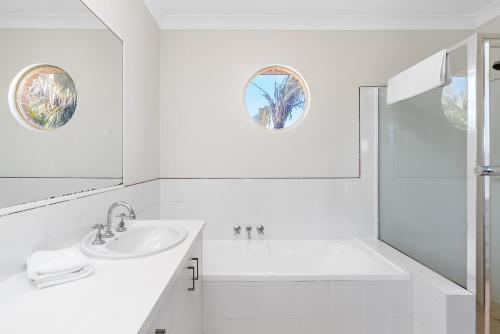 拜伦湾Bayside Court Apartments的白色的浴室设有水槽和淋浴。
