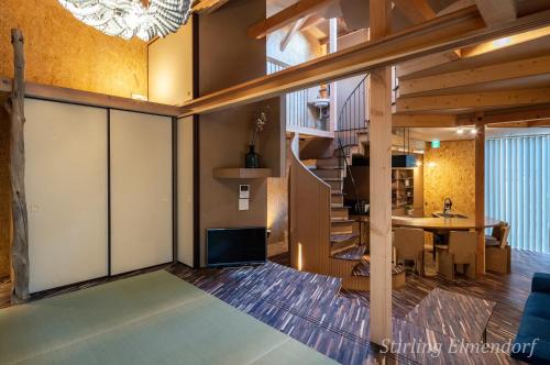 大阪ARCHITEKTON -the villa Tennoji-的一间带楼梯的客厅和一间用餐室