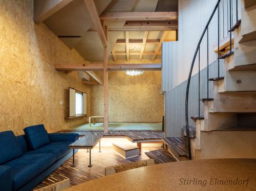 大阪ARCHITEKTON -the villa Tennoji-的客厅配有蓝色的沙发和桌子