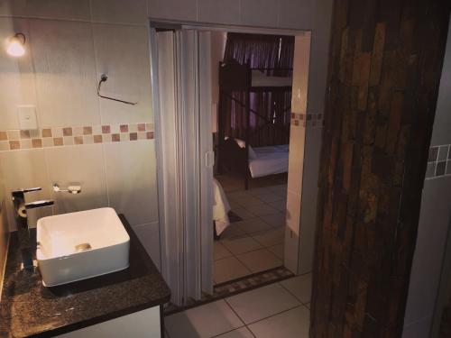 纳布姆斯普雷特AAA Rose Garden Guesthouse的浴室设有白色水槽和镜子