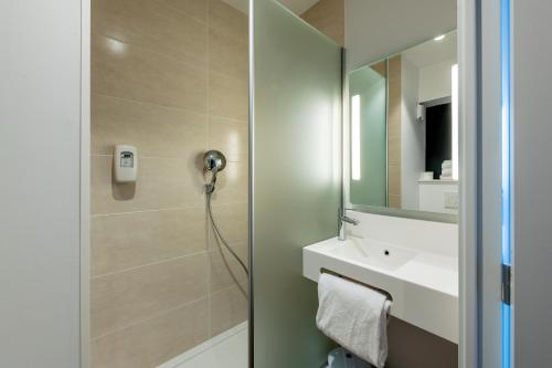 乌伊斯特勒昂B&B HOTEL Ouistreham的带淋浴、盥洗盆和镜子的浴室