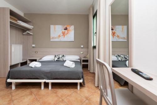 比萨卡萨贝塔尼亚酒店的一间卧室配有一张床、一张书桌和一张书桌