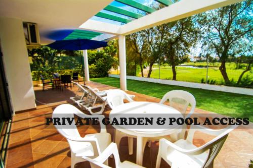 滨海罗克塔斯Roquetas Beach and Playa Serena Golf Village的庭院配有桌椅和遮阳伞。