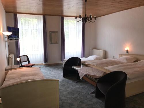 莱茵河畔的宾根Rheinhotel Starkenburger Hof的一间卧室设有两张床、一张桌子和窗户。