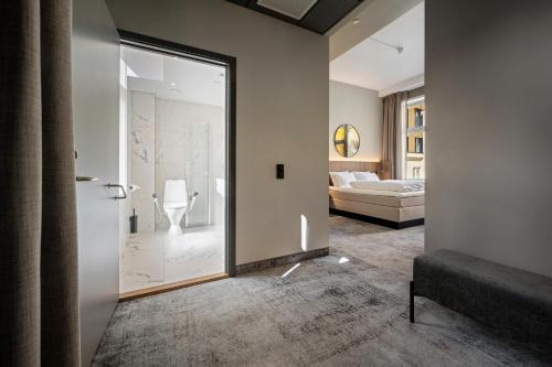 奥斯陆Karl Johan Hotel的浴室设有玻璃门,可通往卧室