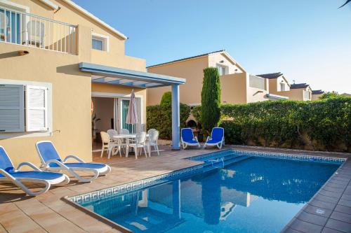 Son CarrioSagitario Villas的一座别墅,设有游泳池、椅子和一座房子