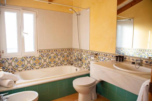 Son CarrioSagitario Villas的带浴缸、卫生间和盥洗盆的浴室