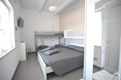 朱利亚诺瓦Agriturismo Frontemare的白色卧室配有双层床和镜子