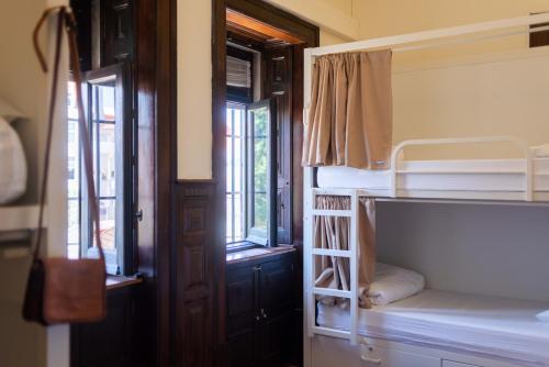 里斯本Sant Jordi Hostels Lisbon的客房设有两张双层床和一扇窗户。