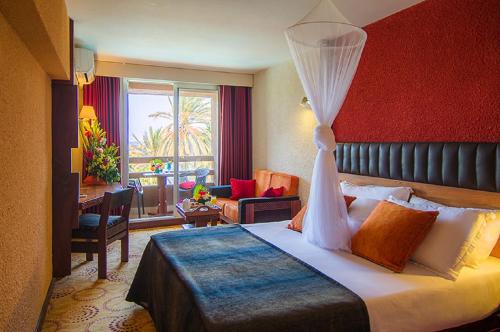 达喀尔达喀尔翡翠花园酒店的酒店客房设有一间带一张床和一张书桌的卧室