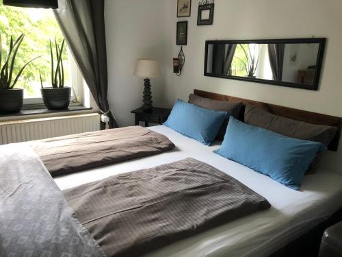 卡尔卡尔Zweitheimat的一间卧室配有一张带蓝色枕头和镜子的床