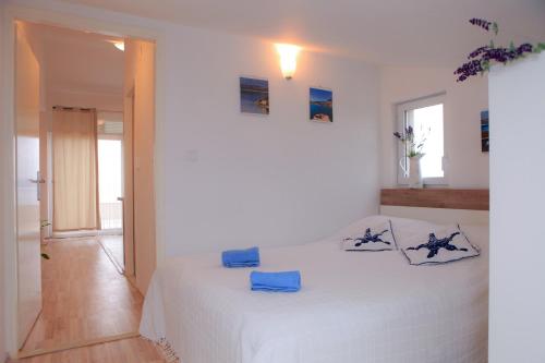 诺维格勒达尔马提亚Apartments Villa Marija的白色卧室配有蓝色枕头的床
