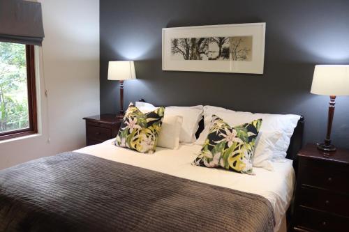 白河Heuglins Lodge的一间卧室配有带白色床单和枕头的床。