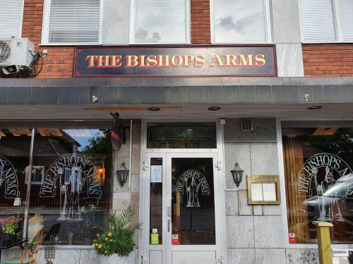 莫拉Hotel Bishops Arms Mora的一座建筑物,上面有读过酒馆手臂的标志