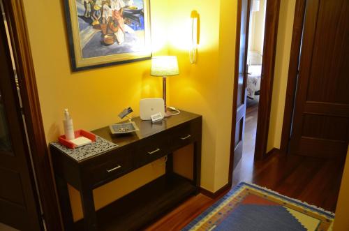 格罗韦Apartamento en Beiramar的配有一张桌子、一盏灯和一扇黄色墙壁的房间