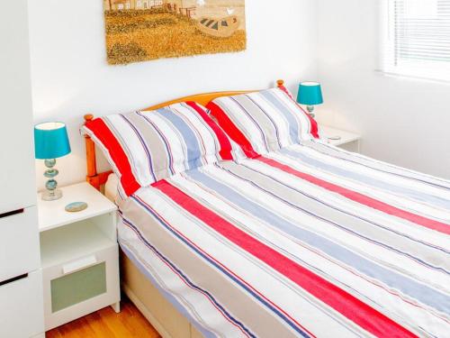 达特茅斯Hi-De-Hi Chalet 111的一张带红白色和蓝色条纹毯子的床