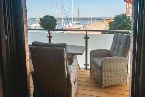 巴特Lütt Haven的阳台上配有两把椅子和一张桌子,还带有船只
