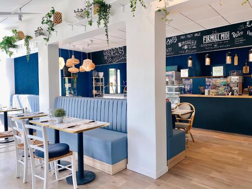 韦尔东河畔拉帕吕Hotel Le Provence - Restaurant Le Styx的餐厅拥有蓝色的墙壁,配有桌椅