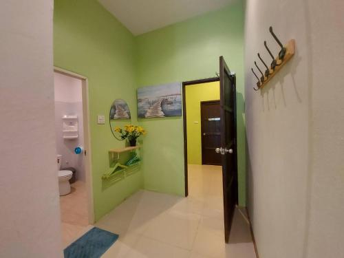 沙美岛巴恩奥姆苏步旅馆的走廊上设有浴室,浴室内有绿色的墙壁和门