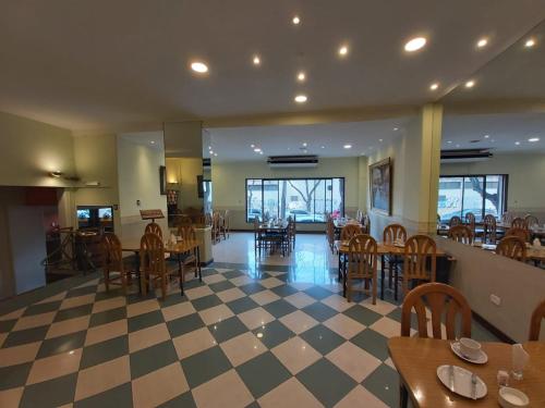 门多萨阿里奥斯托酒店的一间带桌椅和 ⁇ 制地板的餐厅