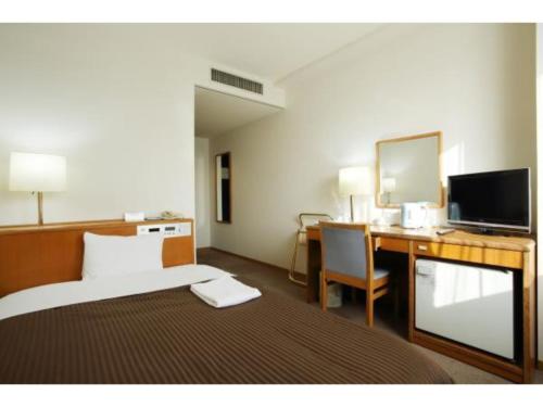 冈山SAIDAIJI GRAND HOTEL - Vacation STAY 92835的酒店客房配有一张床和一张带电脑的书桌