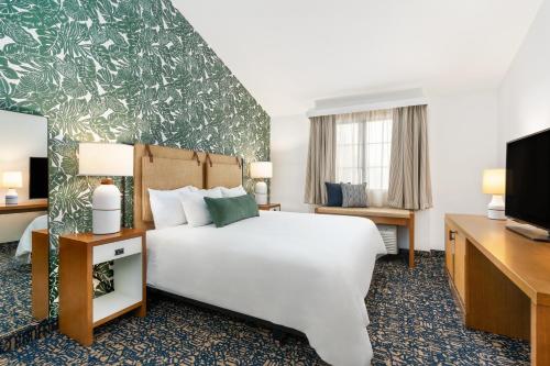 圣巴巴拉梅森海滩旅馆的一间酒店客房,配有一张床和一台电视