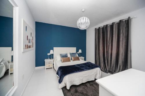 宏达海滩Luxury Suite Sea Front II的一间卧室设有一张床和蓝色的墙壁