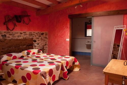 塞代拉卡尔萨达罗马娜旅馆的一间设有床铺的卧室,位于一个红色墙壁的房间
