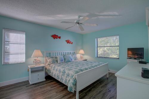 布雷登顿海滩Anna Maria Island Beach Palms 7A的一间卧室配有一张床和吊扇