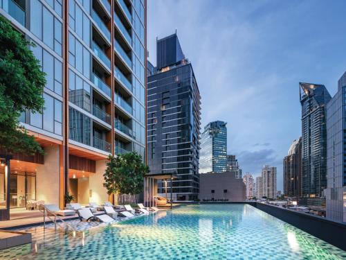 曼谷曼谷橡树套房酒店的一座位于城市中心,拥有建筑物的游泳池