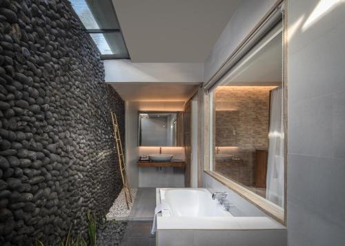 普卢坎Umadewi Surf & Retreat的浴室配有盥洗盆和浴缸。