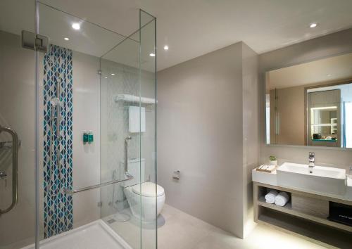 芭堤雅市中心芭堤雅遨舍度假酒店的浴室配有卫生间、盥洗盆和淋浴。