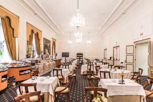 毕尔巴鄂卡尔顿酒店的餐厅配有白色的桌椅和吊灯