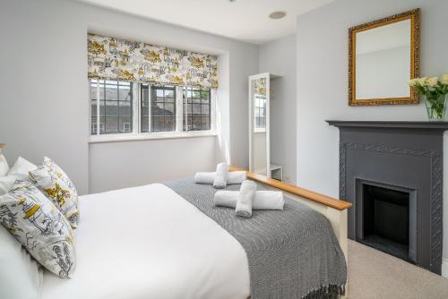温莎Castle Properties:Eton-The College的一间卧室配有一张床和一个壁炉