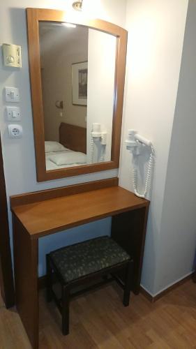 雅典经济酒店的浴室设有木制梳妆台和镜子