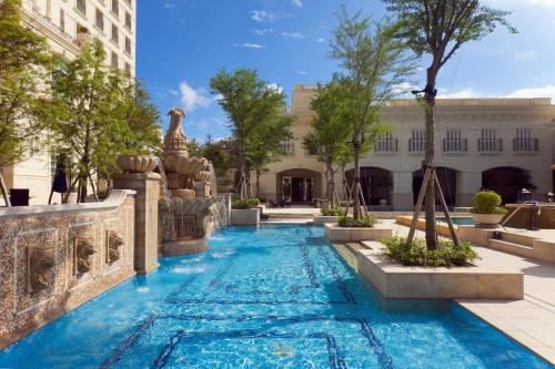 苏澳珑山林苏澳冷热泉度假饭店的一座建筑中间的游泳池,带喷泉