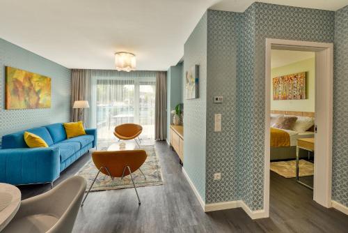 萨尔瓦尔Club Luxury Apartman的一间带蓝色沙发的客厅和一间卧室