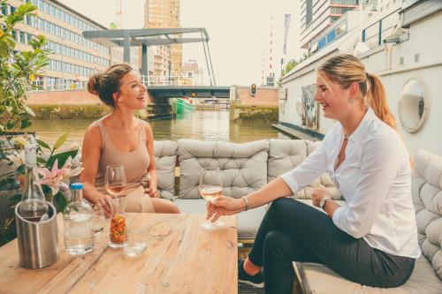 鹿特丹鹿特丹水上酒店的两个女人坐在桌子上,戴着酒杯