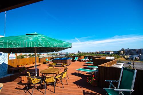 蒂米什瓦拉Best Western Plus Lido Hotel的一个带桌椅和绿色遮阳伞的庭院
