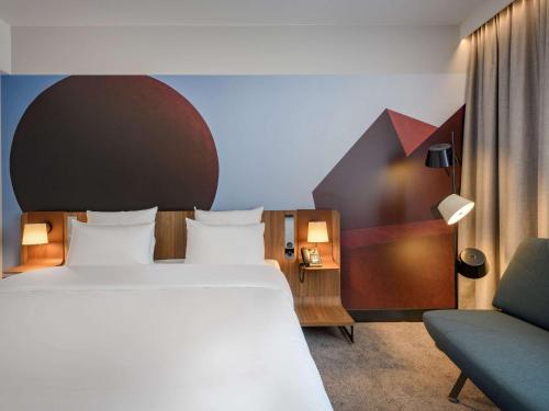雷根斯堡Novotel Regensburg Zentrum的配有一张床和一把椅子的酒店客房