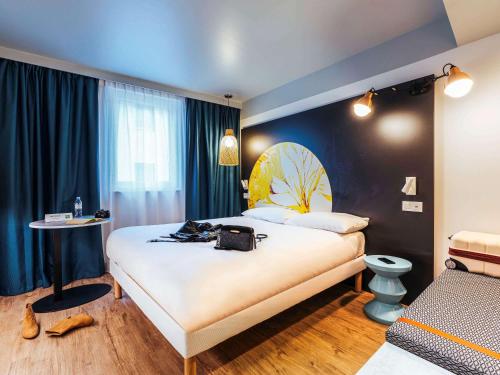 梅尔·莱斯·拜恩斯ibis Styles Le Treport Mers Les Bains的酒店客房设有一张大床和一张桌子。