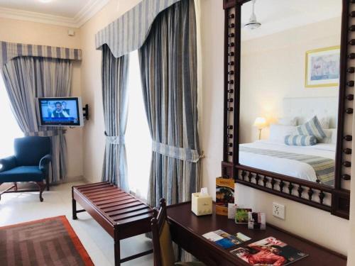 卡拉奇海滩豪华酒店的一间带大镜子和床的卧室