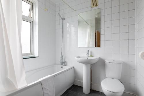 哈罗Euro Hotel Harrow的白色的浴室设有水槽、卫生间和浴缸。
