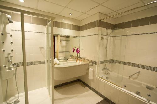 麦纳麦One Pavilion Luxury Serviced Apartments的带浴缸、水槽和淋浴的浴室