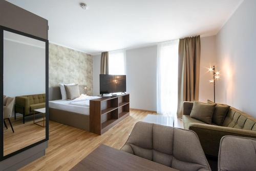 乌尔姆Brera Serviced Apartments Ulm的酒店客房,配有床和沙发