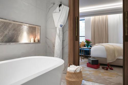迪拜Al Jaddaf Rotana Suite Hotel的带浴缸的浴室和卧室