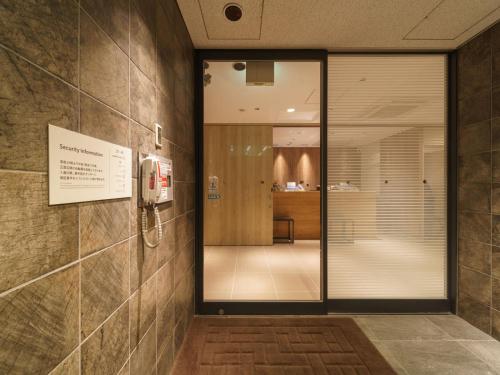 东京横丁品川青物超级酒店的一个带玻璃门的大堂和一间房间