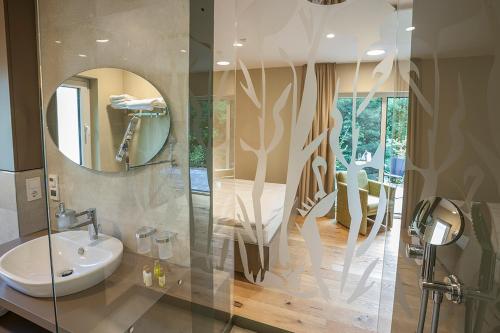 瓦登Hotel Weiherhof am Golfpark的一间带水槽和镜子的浴室